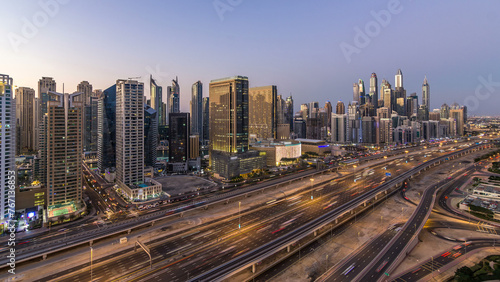 Dubai marina with traffic on sheikh zayed road panorama day to night timelapse lights turn on. © neiezhmakov