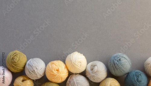 rainbow wool yarn balls on gray background with ample text space for design or advertising