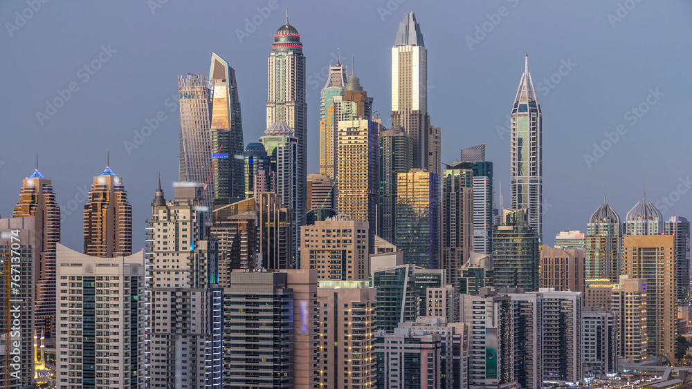 Dubai marina with traffic on sheikh zayed road panorama day to night timelapse lights turn on.