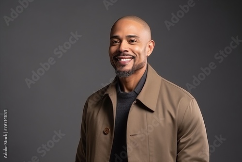 Handsome african american man in coat on grey background
