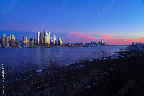 WEEHAWKEN, NJ -18 FEB 2024- Sunset view of the waterfront skyline in Manhattan, New York, seen from across the Hudson River in New Jersey. photo