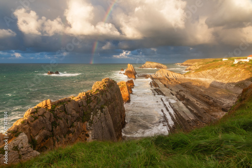Rainbow over Playa de la Arnia in Santander, Cantabria, North Spain with cliffs and flysch rocks. Popular travel destination