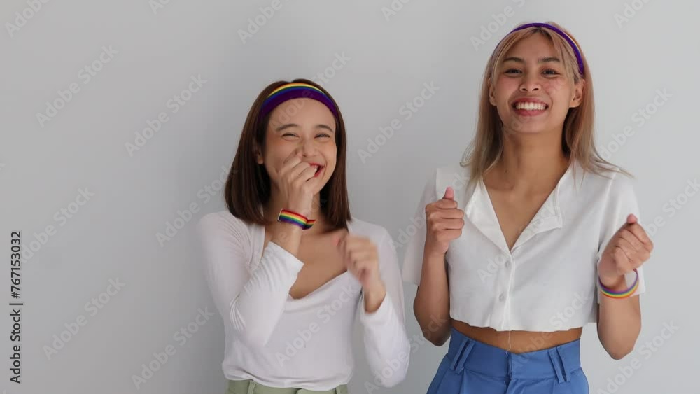 Happy LGBT Women Wearing Rainbow Wristband and Headband dancing, Concept image of Celebration, Empowerment and Pride of LGBT people Happy LGBT Women Wearing Rainbow Wristband and Headband dancing, Concept image of Celebration, Empowerment and Pride of LGBT people