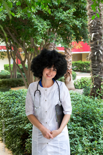 Woman doctor with curly hair outdoor portrait.