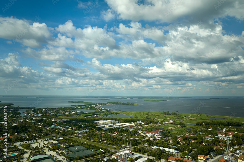 Aerial view of wealthy waterfront neighborhood. Expensive mansions between green palm trees on Gulf of Mexico shore in island small town Boca Grande on Gasparilla Island in southwest Florida, USA Aerial view of wealthy waterfront neighborhood. Expensive mansions between green palm trees on Gulf of Mexico shore in island small town Boca Grande on Gasparilla Island in southwest Florida, USA