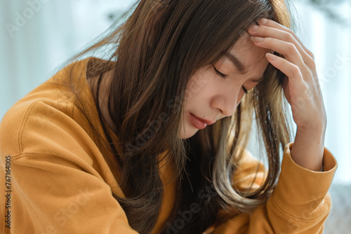 Closeup - Depressed young woman sitting on couch in the living room at home, Frustrated confused female feels unhappy problem in personal life quarrel break up with boyfriend
