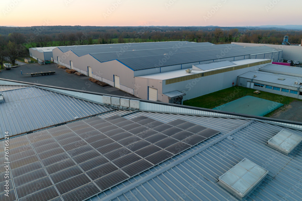 Aerial view of blue photovoltaic solar panels mounted on industrial building roof for producing green ecological electricity. Production of sustainable energy concept Aerial view of blue photovoltaic solar panels mounted on industrial building roof for producing green ecological electricity. Production of sustainable energy concept