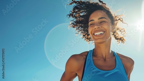 Active woman smiling with sun flare. Close-up outdoor fitness portrait with copy space.
