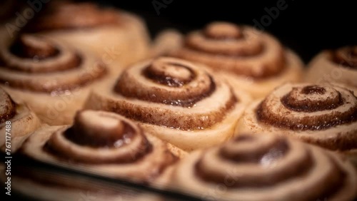 A timelapse of baking homemade sweet rolls in the oven. Traditional American rolls made of yeast dough with a filling of cinnamon and sugar, glazed with cream cheese, powdered sugar and vanilla.