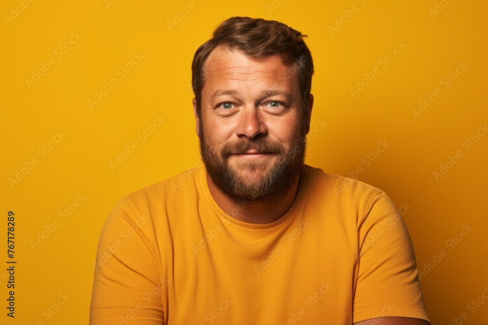 Portrait of a bearded man in a yellow t-shirt on a yellow background Portrait of a bearded man in a yellow t-shirt on a yellow background