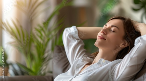 Peaceful Caucasian woman is laying on a couch feeling relaxed and peace.