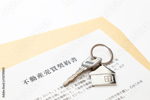 Foto 白背景に不動産売買契約書と鍵