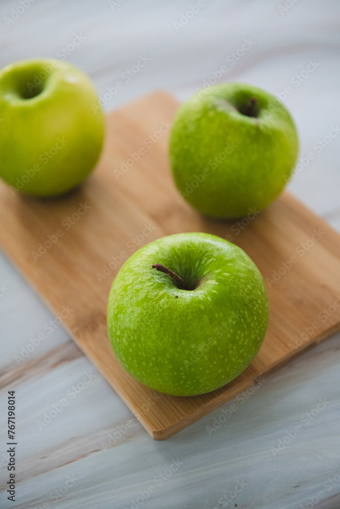 Green apples, granny smith on a bamboo cutting board Green apples, granny smith on a bamboo cutting board