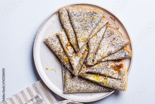 Crepes with poppy seeds, maple syrup and zest. photo