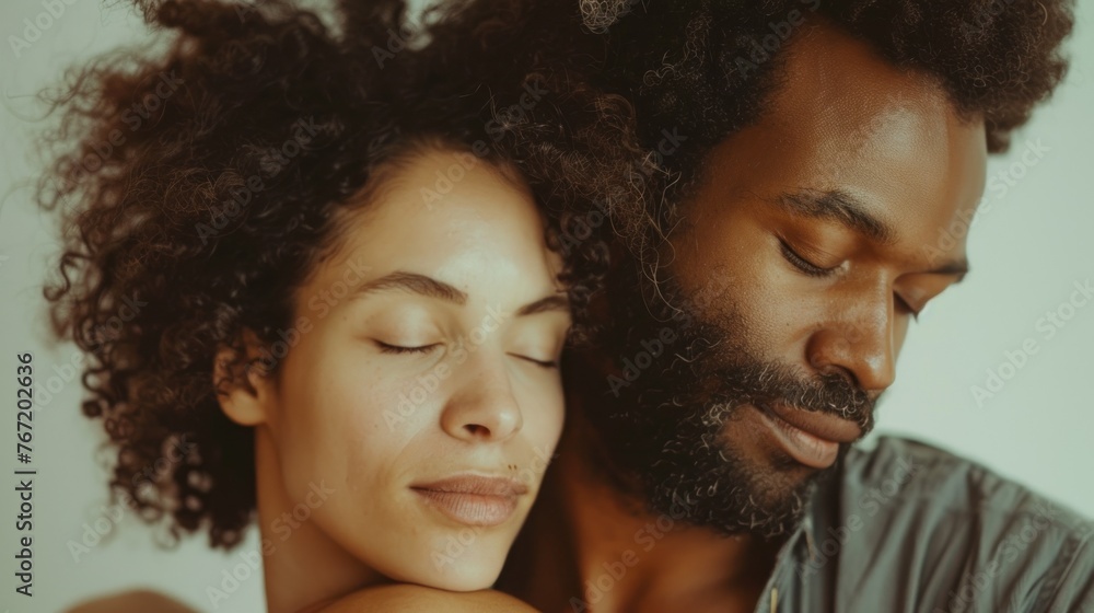 A close-up of a man and woman in a loving embrace both with closed eyes suggesting a moment of intimacy and tranquility. A close-up of a man and woman in a loving embrace both with closed eyes suggesting a moment of intimacy and tranquility.