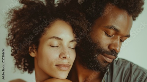 A close-up of a man and woman in a loving embrace both with closed eyes suggesting a moment of intimacy and tranquility.