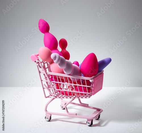anal plugs and dildo sex toys in sex shop shopping cart isolated on white background