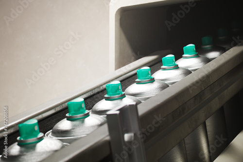 Industrial Conveyor Belt Lined With Uniform Metal Containers & Green Lids