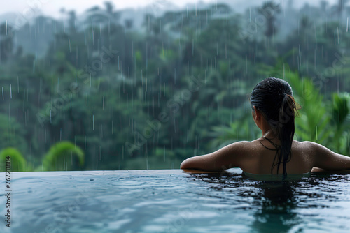 woman relaxing in infinity pool with view of rain forest © Sergio