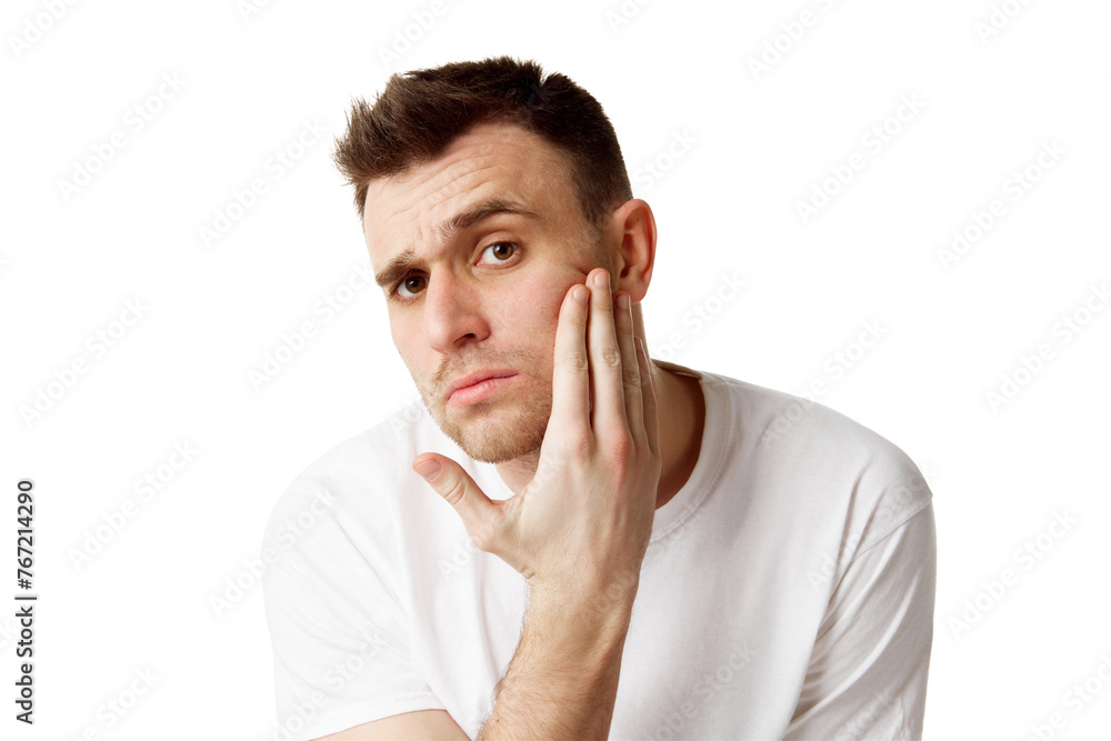 Young man touching his face and looking at camera with curious facial expression against white studio background. Concept of natural beauty, spa treatments, masculine, cosmetology. Young man touching his face and looking at camera with curious facial expression against white studio background. Concept of natural beauty, spa treatments, masculine, cosmetology.