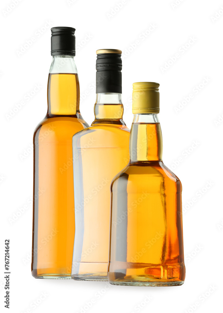 Different sorts of whiskey in glass bottles isolated on white Different sorts of whiskey in glass bottles isolated on white