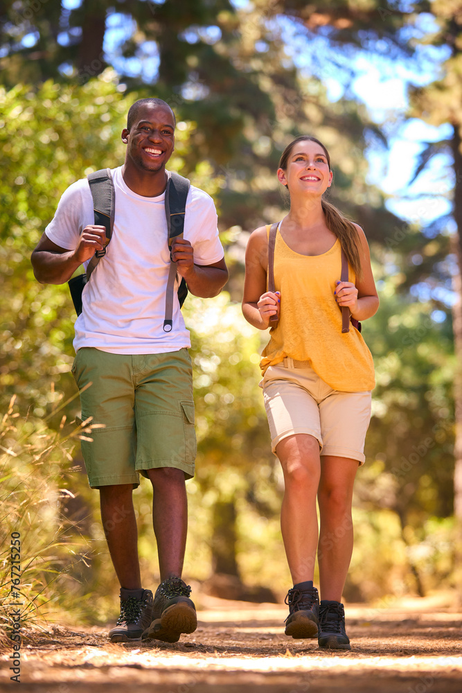Young Active Couple Wearing Backpacks Hiking Along Trail Through Countryside Young Active Couple Wearing Backpacks Hiking Along Trail Through Countryside