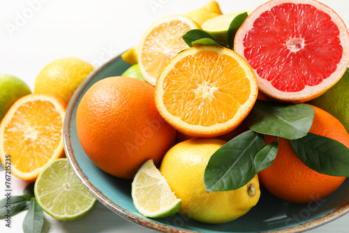 Different cut and whole citrus fruits on white table, closeup