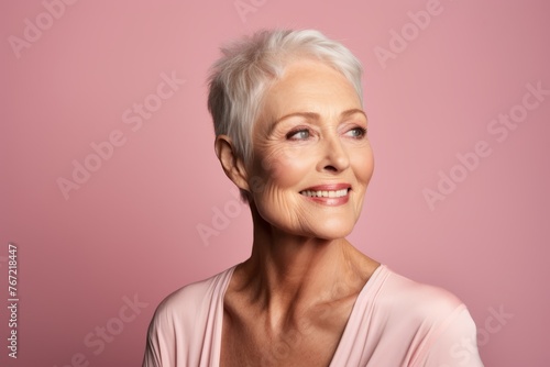 Portrait of a happy senior woman looking at camera over pink background