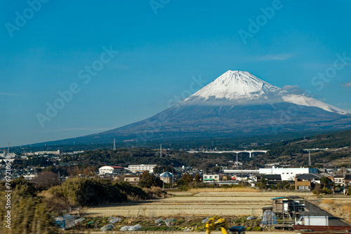 Scenic view of famous volcano Mount Fuji seen trough window train with blue sky background. Photo taken January 30th  2024  Japan.