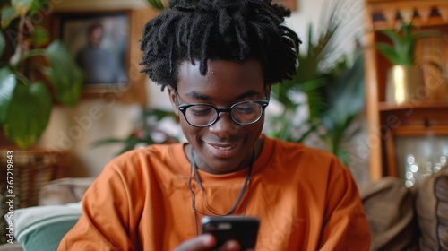 Man in Orange Shirt Using Cell Phone