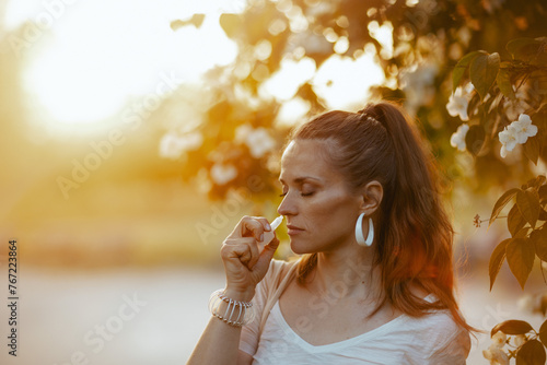 stylish female in white shirt using nasal spray