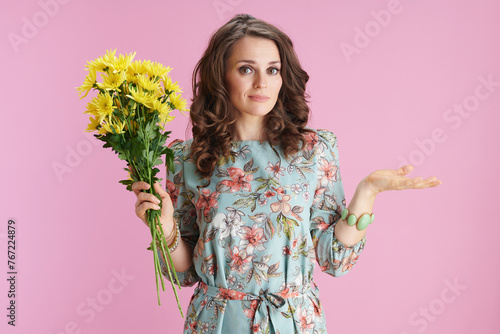 stylish female in floral dress shrugging on pink