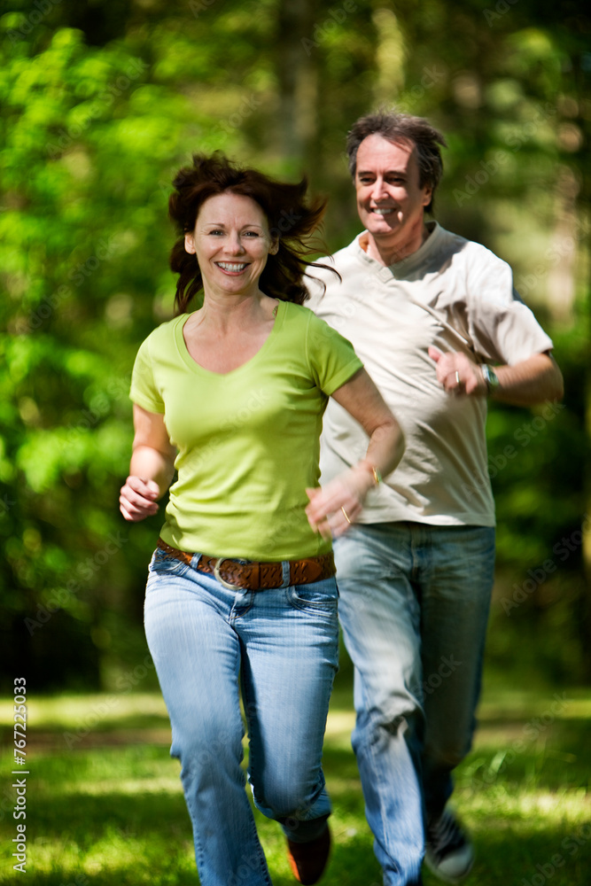 Life begins at 40. A carefree mature couple enjoying a young-at-heart moment running through a sunny woodland. Life begins at 40. A carefree mature couple enjoying a young-at-heart moment running through a sunny woodland.