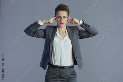 stressed elegant female employee isolated on gray background