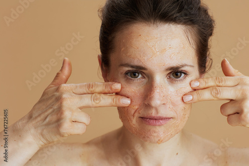 woman with face scrub on beige background