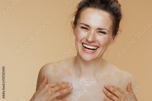 smiling modern female rubbing body cream