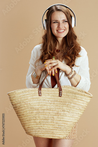 happy stylish housewife listening to music on beige