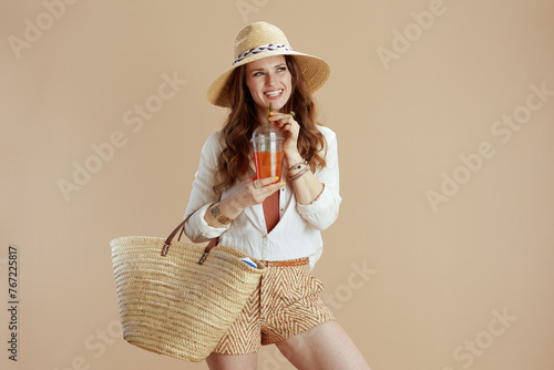 happy woman in blouse and shorts against beige