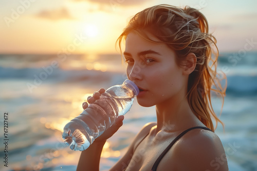 Woman drinking water on the beach