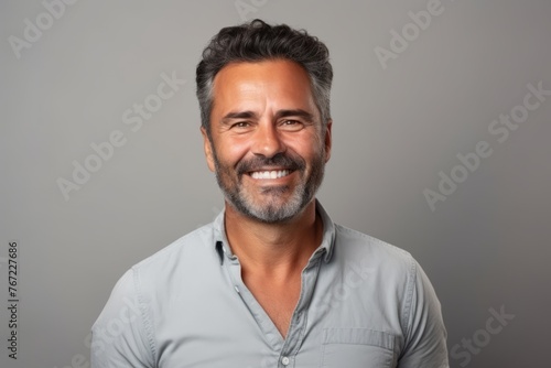 Handsome middle-aged Indian man smiling and looking at camera.