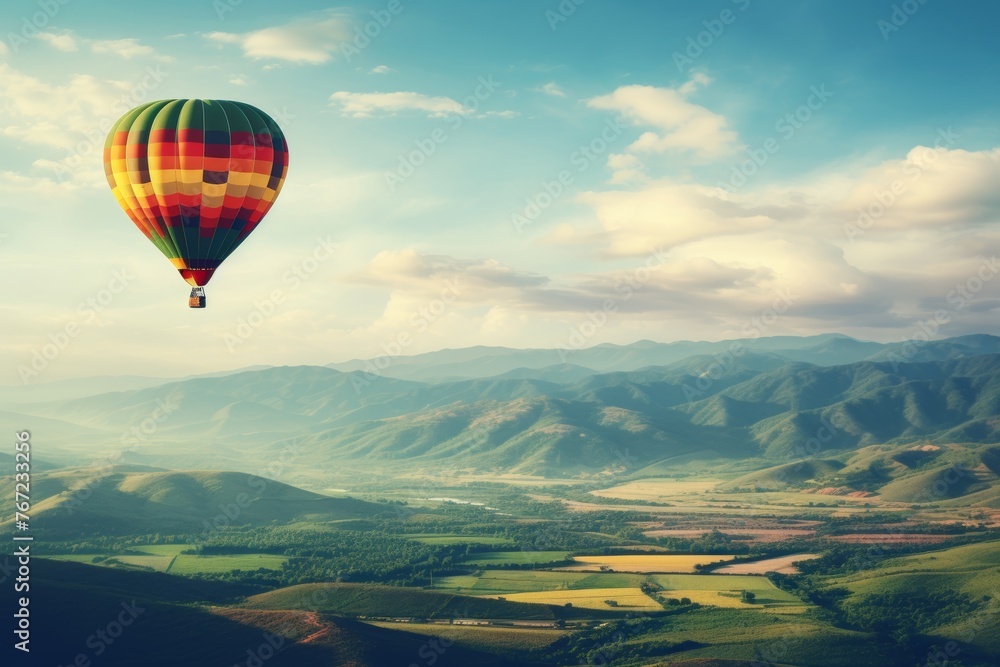 Aerial view of hot air balloon flying above verdant fields with ample space for text