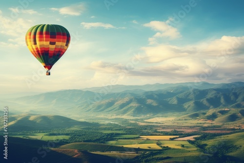 Aerial view of hot air balloon flying above verdant fields with ample space for text © Aliaksandra
