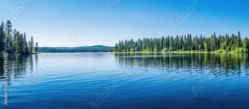 A tranquil lake surrounded by trees and distant mountains