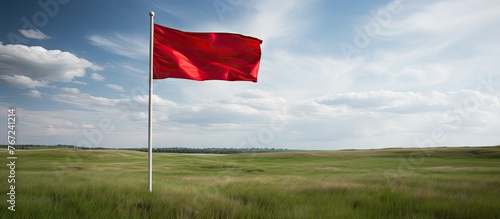 Red flag waving in wind on field