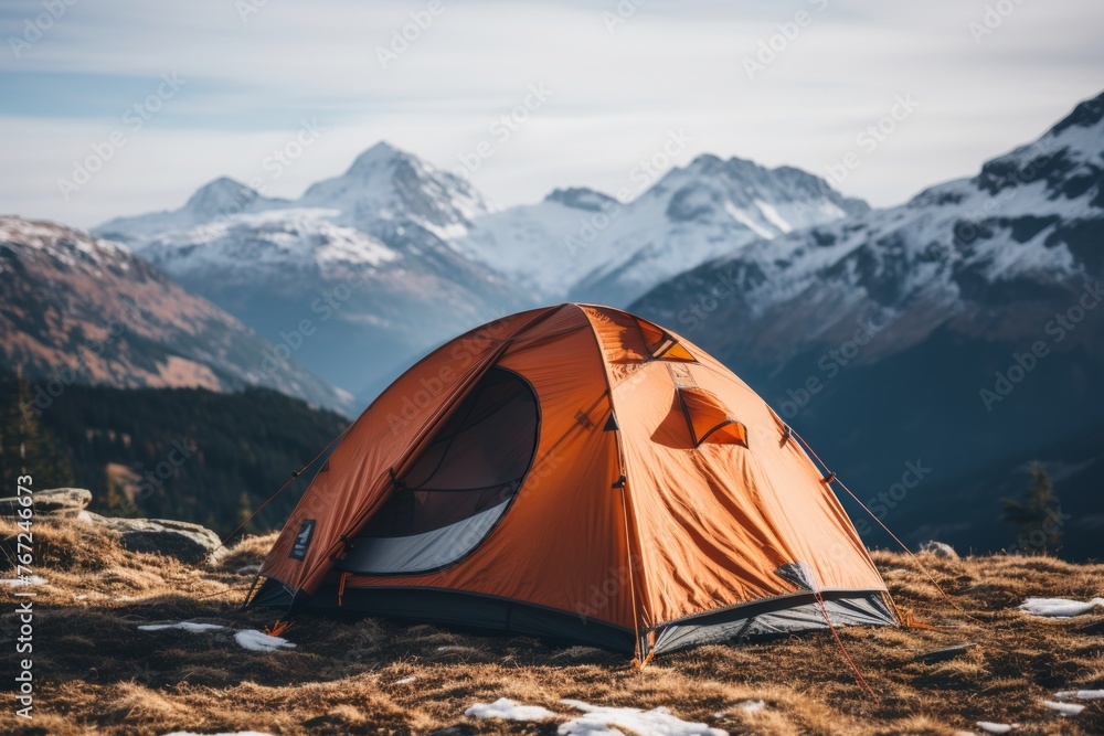 Scenic winter camping adventure at the base of majestic snow-capped mountain peaks