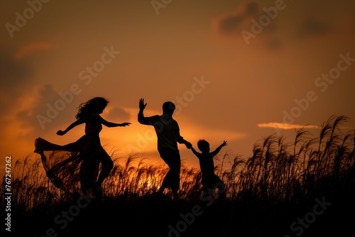 Family of silhouettes against sunset sky
