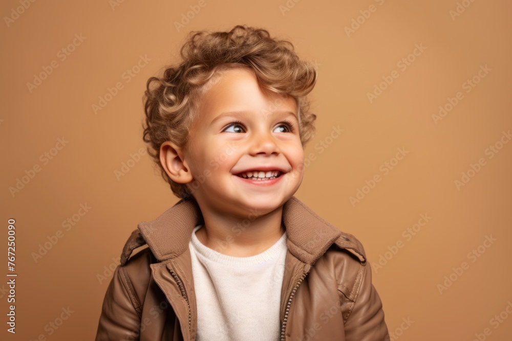 Portrait of a cute little boy in a brown jacket on a brown background Portrait of a cute little boy in a brown jacket on a brown background