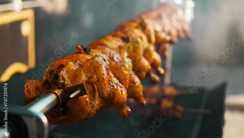 Close up video of grilling whole chicken outdoors.