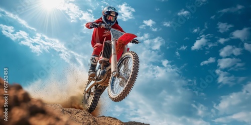 Dirt biker jumps creating dust trail photo