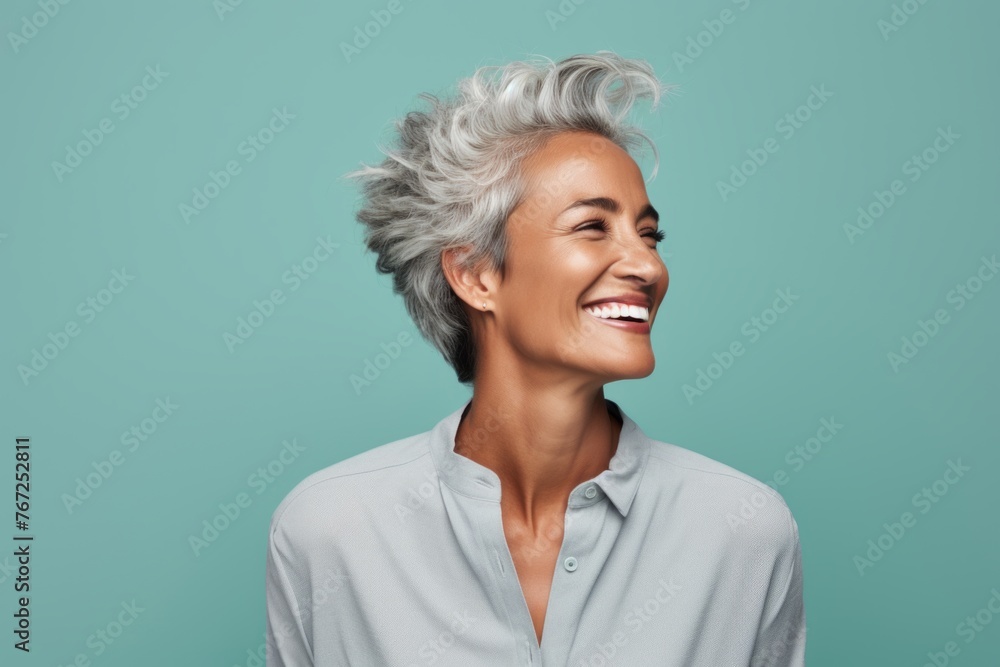 Cheerful middle aged woman with short grey hair laughing and looking away Cheerful middle aged woman with short grey hair laughing and looking away